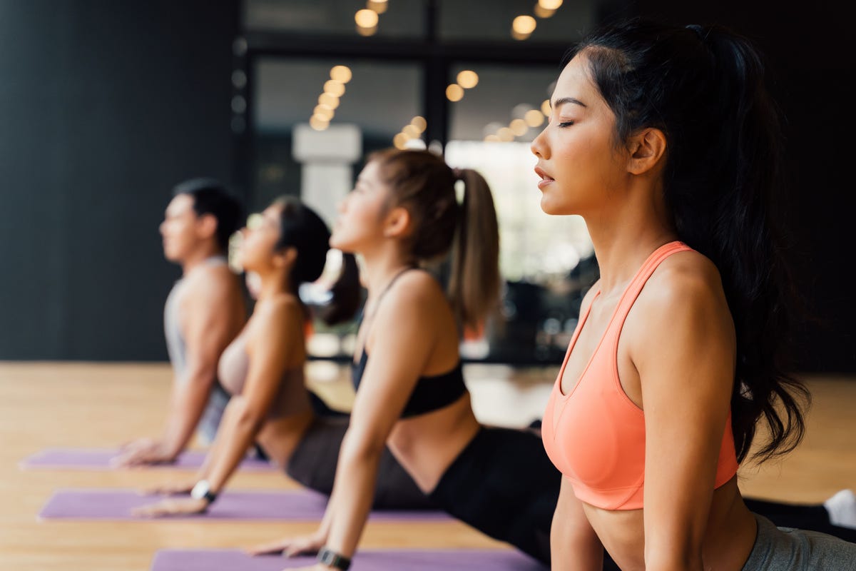 Young women and men exercising at the gym